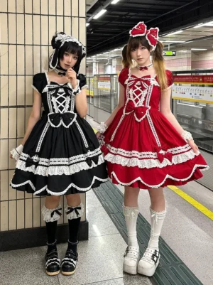 Two female models wearing vintage petal rabbit lolita OP dress in subway station with bow hair ornaments, showcasing black and red color variants with lace trim front cross strap design and ruffled petal hem details