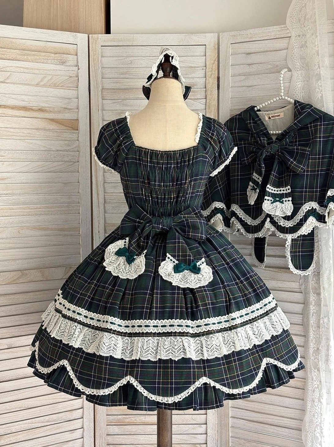 Vintage plaid lolita one-piece dress back view highlighting large bow decoration, lace hem details, and classic Old School silhouette structure