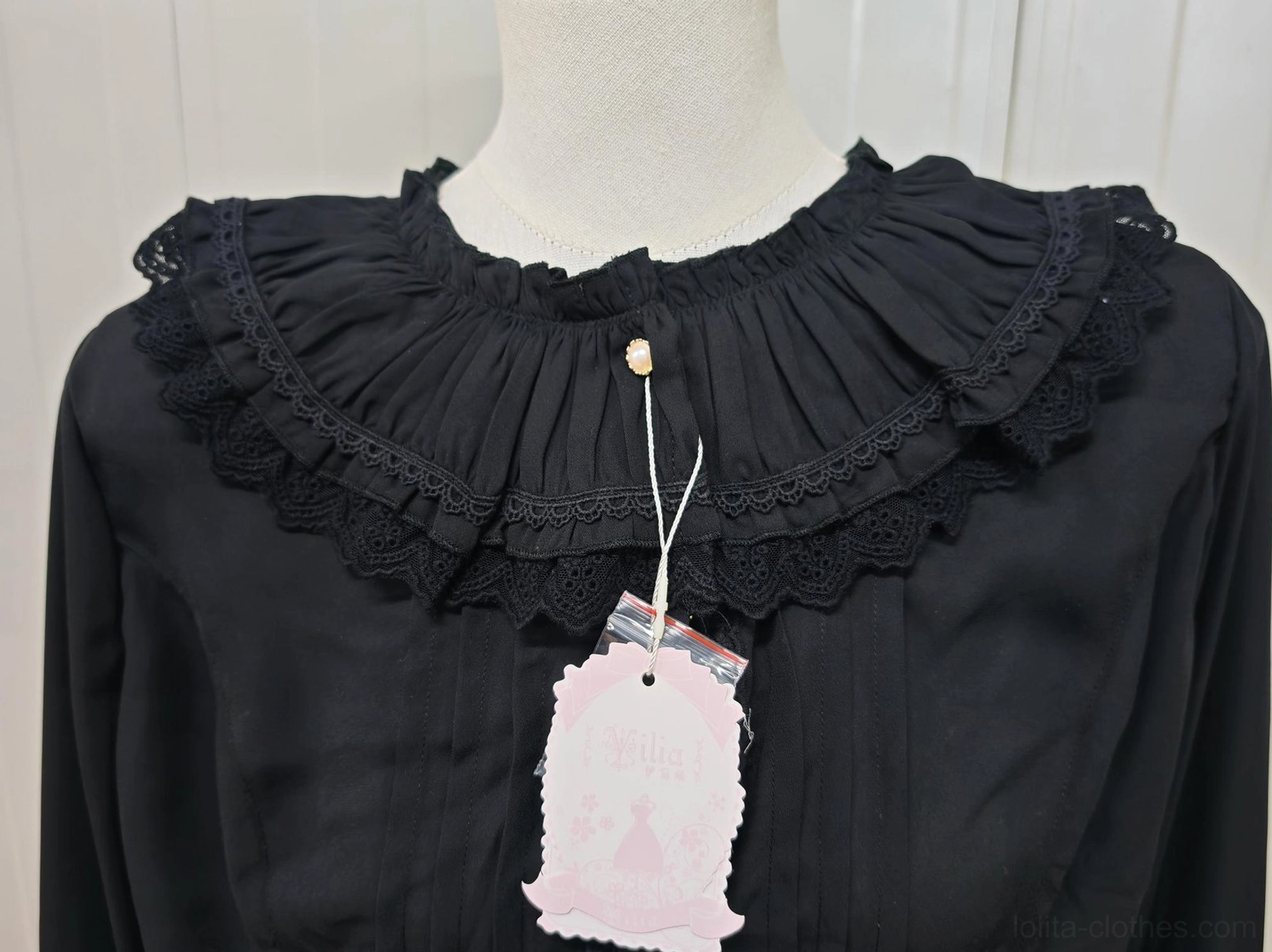 Close-up detail of black lolita blouse neckline showing double-layer ruffled lace collar gold-toned central button gathered pleated neck fabric