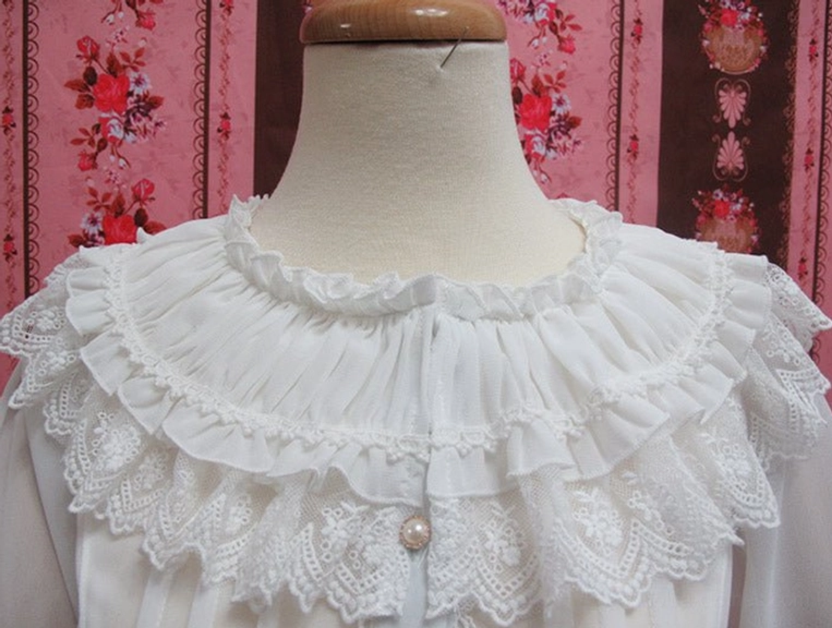 Close-up detail shot of white lolita blouse showing double-layer ruffled lace neckline central pearl button gathered pleated neck fabric