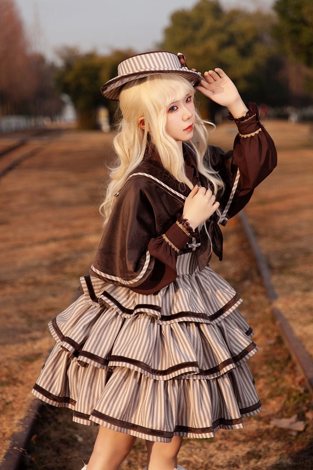 Close-up detail of Lolita JSK layered ruffled cake skirt with brown trim accents and vintage striped fabric pattern, showcasing construction quality and textile density of peppy sailor ensemble