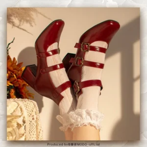 Wine red vintage triple-buckle Mary Jane lolita heels with square toe, glossy patent leather finish, and ornate metal buckle ankle straps, shown with frilled lace socks on-foot display against retro floral background