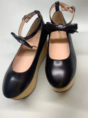 Black glossy patent leather wa lolita platform Mary Jane shoes with round closed toe, adjustable ankle buckle strap, decorative satin bow, and authentic wood-grain wedge platform heel, front flat lay view on light background
