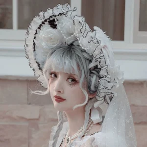 Wedding Lolita bridal bonnet with black scalloped ruffled trim, white base, pearl chain decoration, and attached 1.2 meter sheer veil worn by model with braided silver hair in outdoor European brick setting, paired with white gown and black lace trimmings