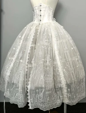 Front studio close-up view of white boning gothic lolita skirt with castle pattern lace fabric, front buttoned closure and scalloped embroidered hem detail