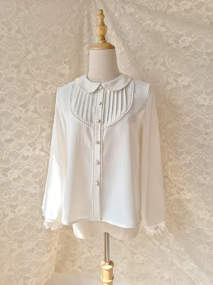 white chiffon lolita blouse peter pan collar displayed on dress mannequin with vintage lace backdrop three-quarter front view