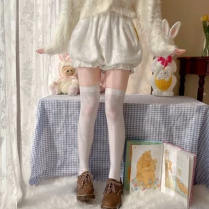 Full-body front coordinate view of white corgi-tail velvet Lolita bloomers styled with fuzzy white sweater thigh-high socks and brown loafers in cozy vintage home setting