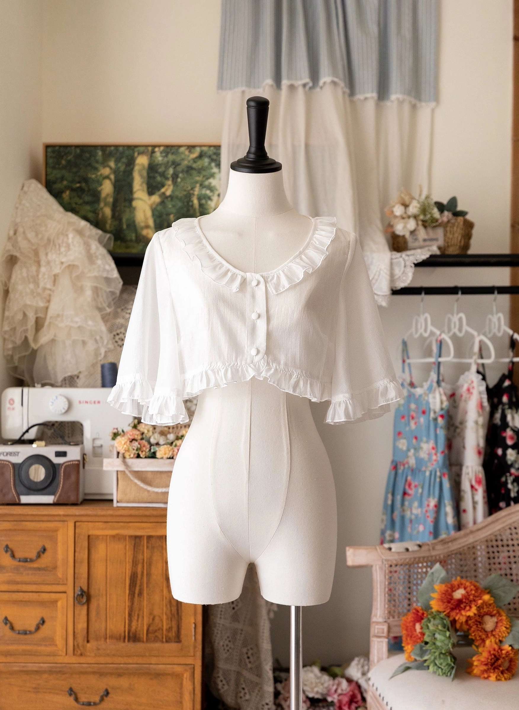 White ruffled short-sleeve cropped Tencel cardigan side-front view showing soft breathable woven fabric, ruffled hem details, front button placket, and perfect proportions for sweet Lolita