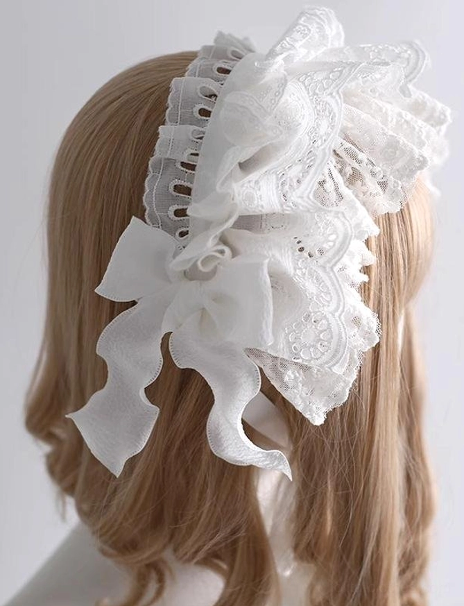 Back side view of white lolita lace hairband demonstrating large embroidered lace bow and hidden secure rear hair clip mechanism