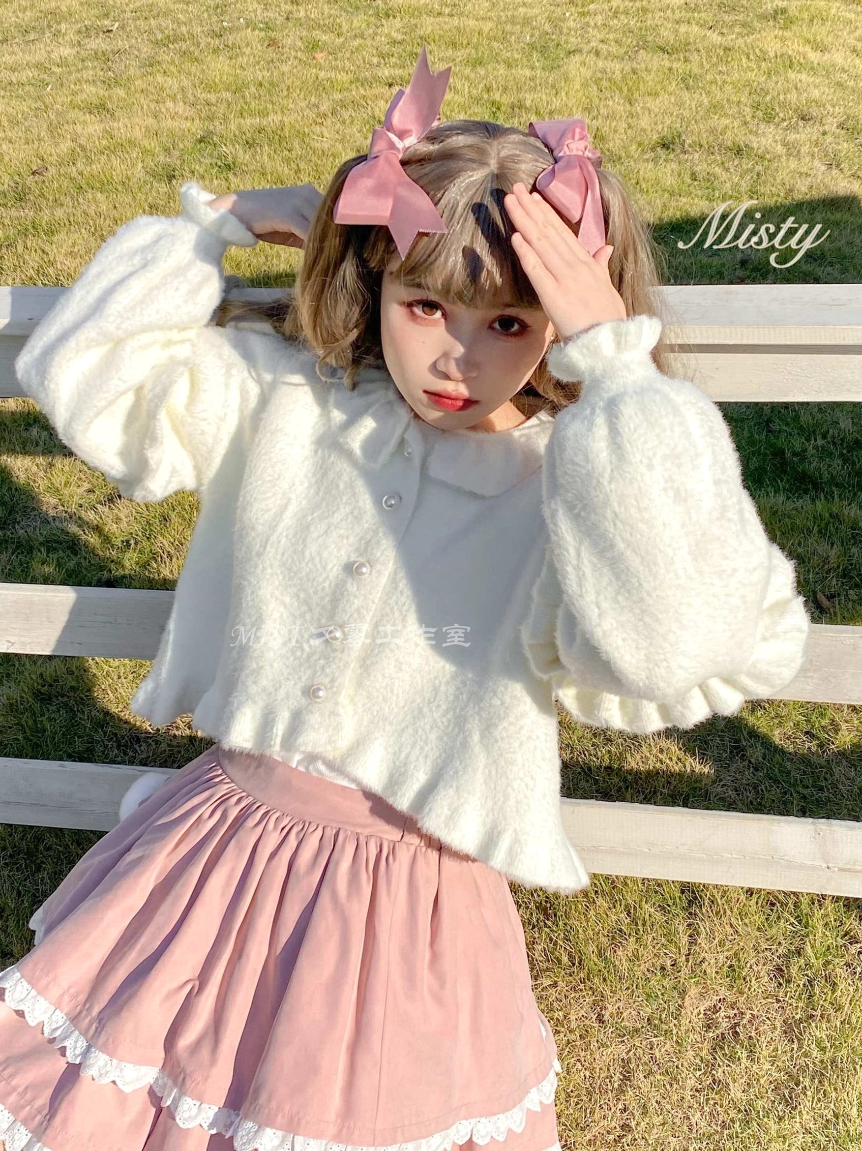 White fluffy lolita cropped cardigan pink ruffled skirt seated front view puff sleeves doll collar soft fuzzy fleece ranch grassland