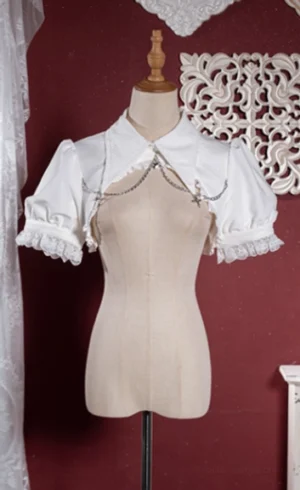 White gothic lolita cropped bubble bolero with puff sleeves lace trim metal chain chest decoration wide lapel collar front flat display vintage decor background