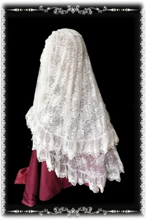 White Gothic Lolita lace veil headdress showcasing delicate layered ruffled edges and floral embroidered design, displayed against vintage decorative frame background