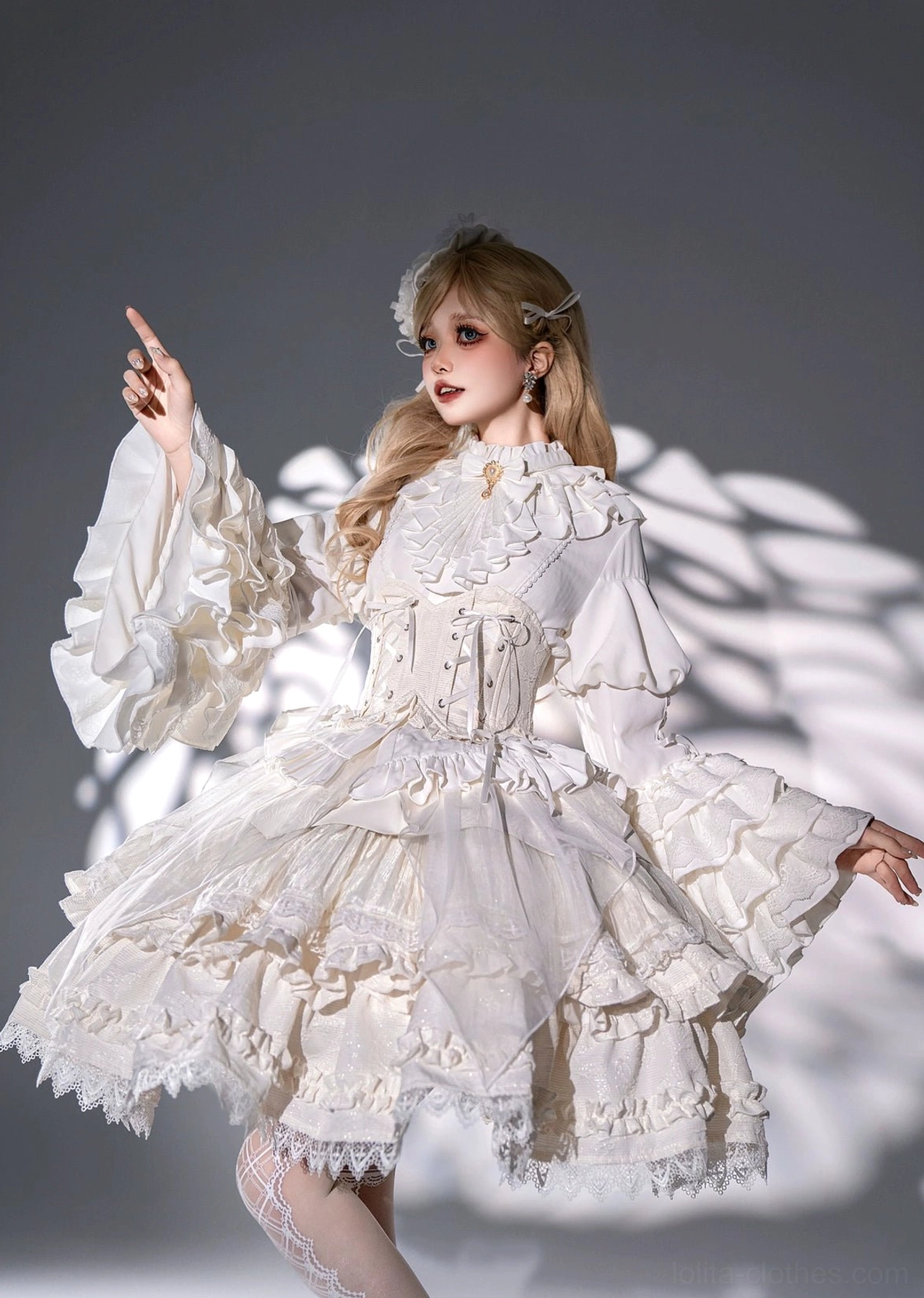 Single model in white gothic lolita princess dress three-quarter pose showing voluminous tiered ruffled skirt oversized puff sleeves and delicate lace trim details