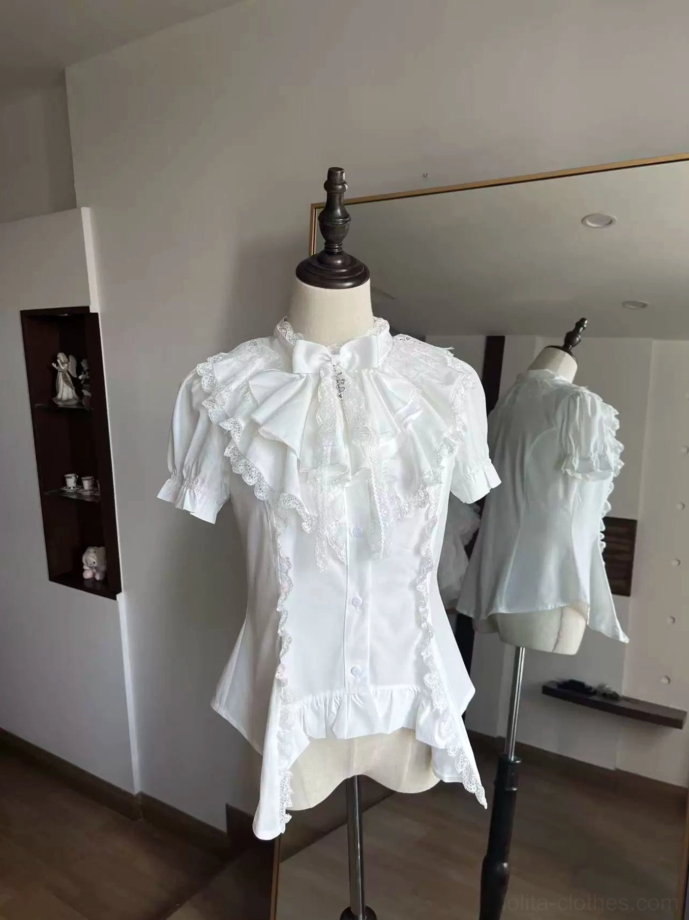 White gothic lolita blouse with detachable bow jabot and crew neck ruffle trim front three-quarter view