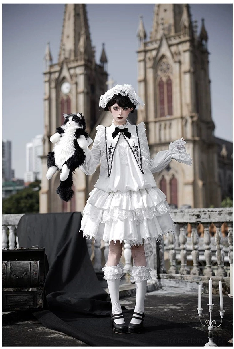 White velvet gothic lolita OP dress front three-quarter angle with tiered ruffled skirt, lace-trimmed collar bow tie and velvet fabric sheen, model holding cute stuffed cat accessory