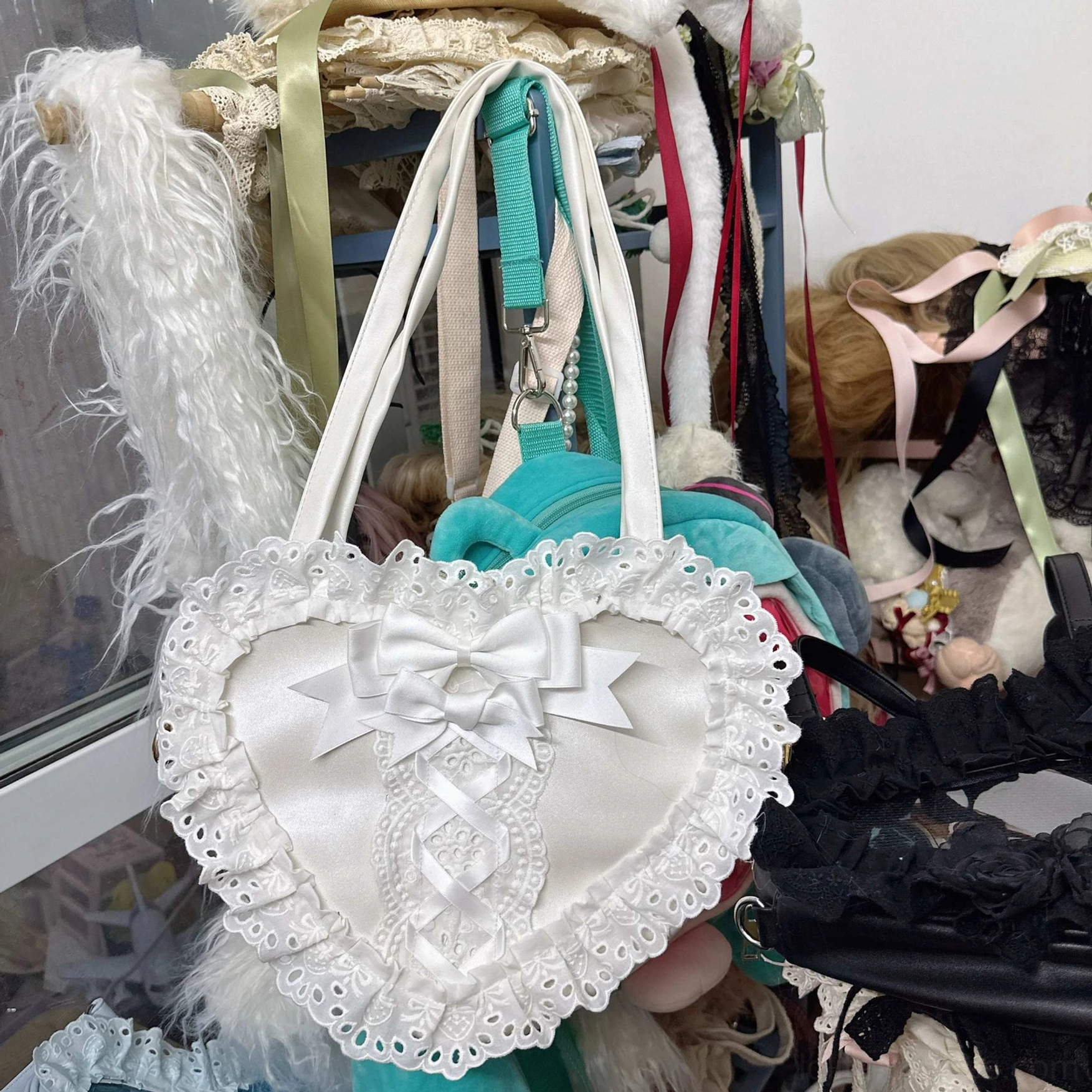 white heart-shaped lace lolita handbag slightly angled front side view with mint green background storage bag