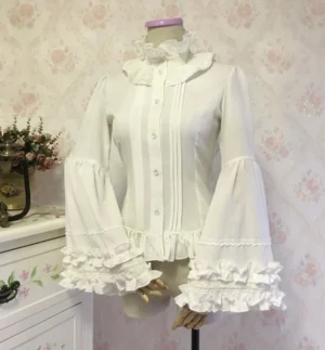 White gothic lolita blouse with adjustable hime sleeves, pleated front placket, and layered ruffled trumpet cuffs on mannequin against vintage floral dresser background, structured bell sleeve design