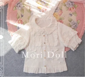 White kawaii rabbit ear lolita blouse with ruffled peter pan collar and integrated rabbit ear hood, overhead flat lay view on floral rug