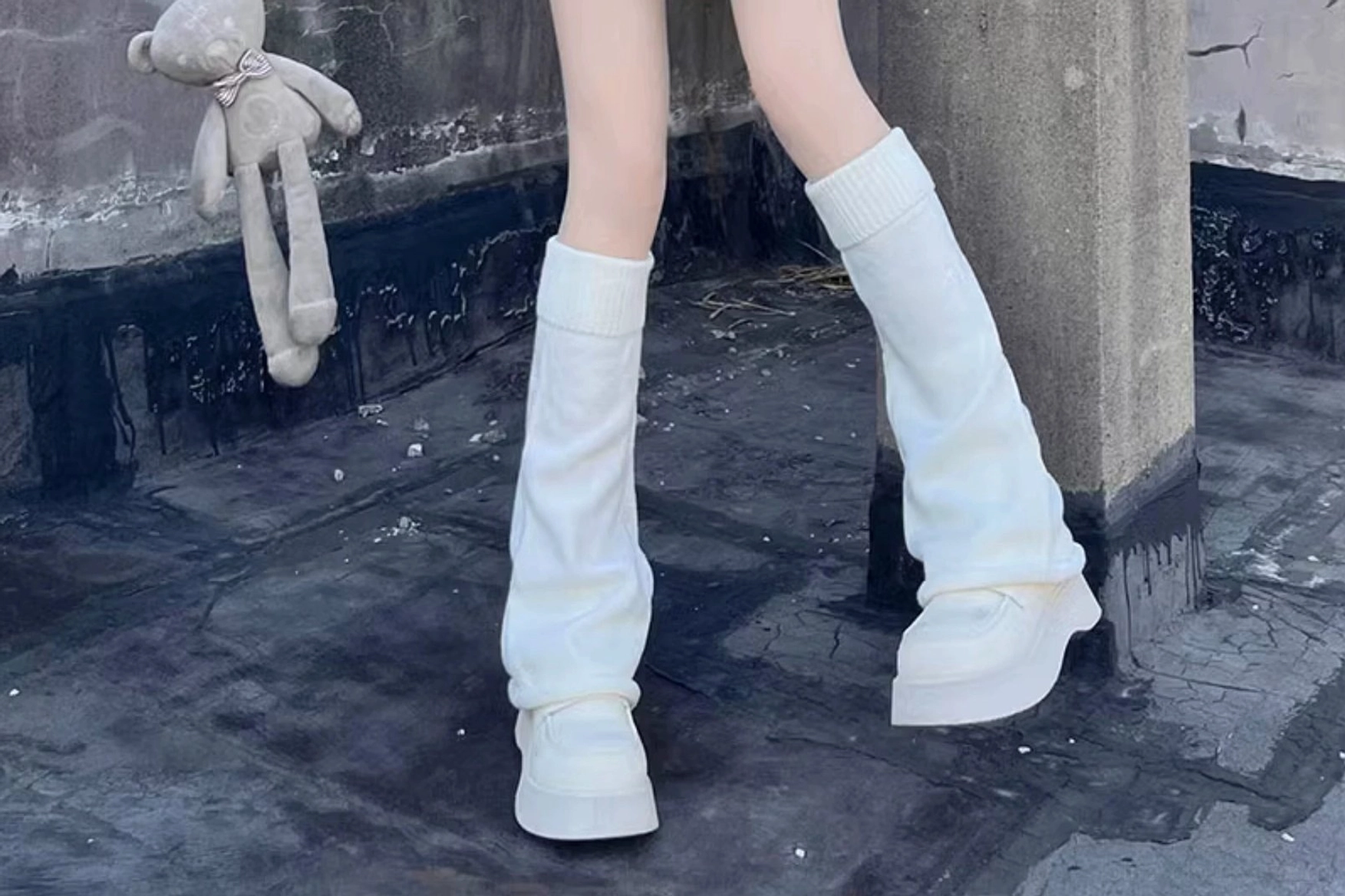 Soft white knitted lolita leg warmers three-quarter side view loose silhouette rooftop platform sneakers plush toy