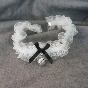 White ruffled lace bell choker with black satin bow and silver bell pendant, flat lay display on neutral background showing adjustable metal clasp and delicate lacework details