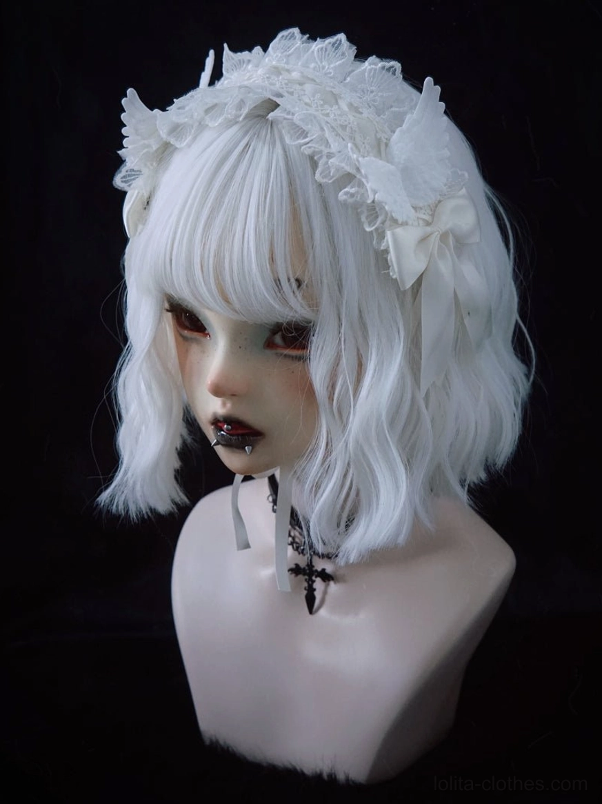 White lace gothic lolita angel wings hairband front three-quarter close-up showing front lace and wing embellishments on BJD bust with cross choker