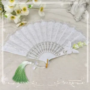 White lace lolita decorative folding fan with white butterfly and light green flower embellishments paired with green gradient tassel and bead pendant on neutral background