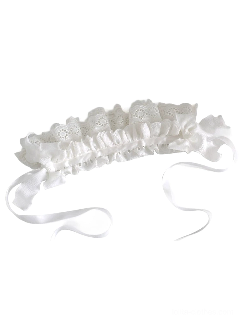 Side flat lay of unworn white embroidered lace lolita hairband showing ruffled eyelet lace, adjustable neck ribbons, and secure hair clip mechanism