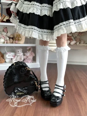 Pure white lace-trimmed sweet lolita mid-calf socks with ruffled cuff and bow accents, worn with black platform Mary Jane shoes and black-white frilly lolita dress, front overhead full lower-body view