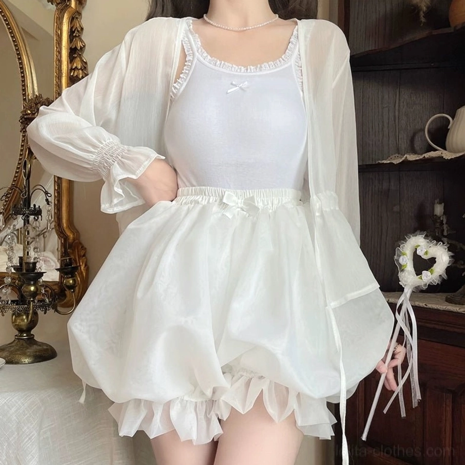 White organza lolita bloomers low-angle close-up displaying oversized puffy silhouette layered ruffled hem lustrous shimmering material and elasticated waist