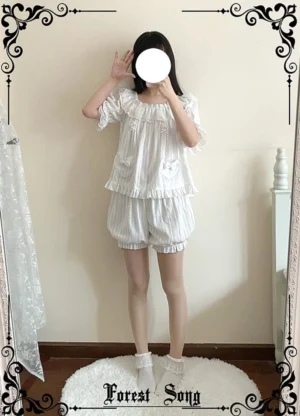 White ruffled Lolita bloomers short length full-body front view standing pose featuring lace neckline with heart bow pocket details and striped textured fabric in home bedroom setting