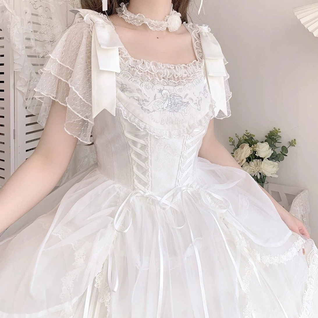 White Lolita blouse with bow-decorated flutter sleeves and lace square neckline, upper body shot on female model
