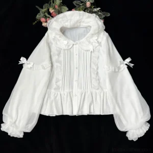 White Lolita blouse with double ruffled Peter Pan collar, front lace pintuck details, decorative sleeve bows and sheer puff cuffs - flat overhead display with floral background