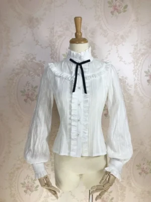 Front flat lay of white sweet lolita cotton blouse displaying ruffled placket, stand collar, pearl buttons, and tailored lantern cuff details