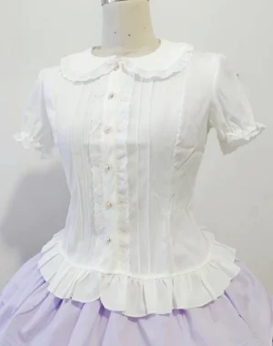 White short-sleeve Lolita blouse with Peter Pan ruffled collar, vertical bodice pintucks, pearl button placket, and coordinated light purple tiered skirt - front full view