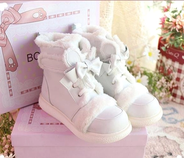 White lolita winter ankle boots low side view on gift box setup showing plush ankle collar, bow lace details, matte white upper, and rounded toe cap