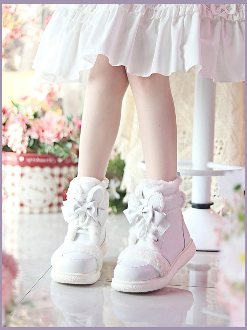 All-white kawaii lolita ankle boots with satin bow laces and soft fleece collar, side low view on model wearing white frilly mini skirt with floral backdrop