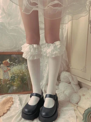 White cotton Lolita mid-calf socks with plain ruffled lace trim cuff paired with black platform Mary Jane shoes indoor vintage lace decor