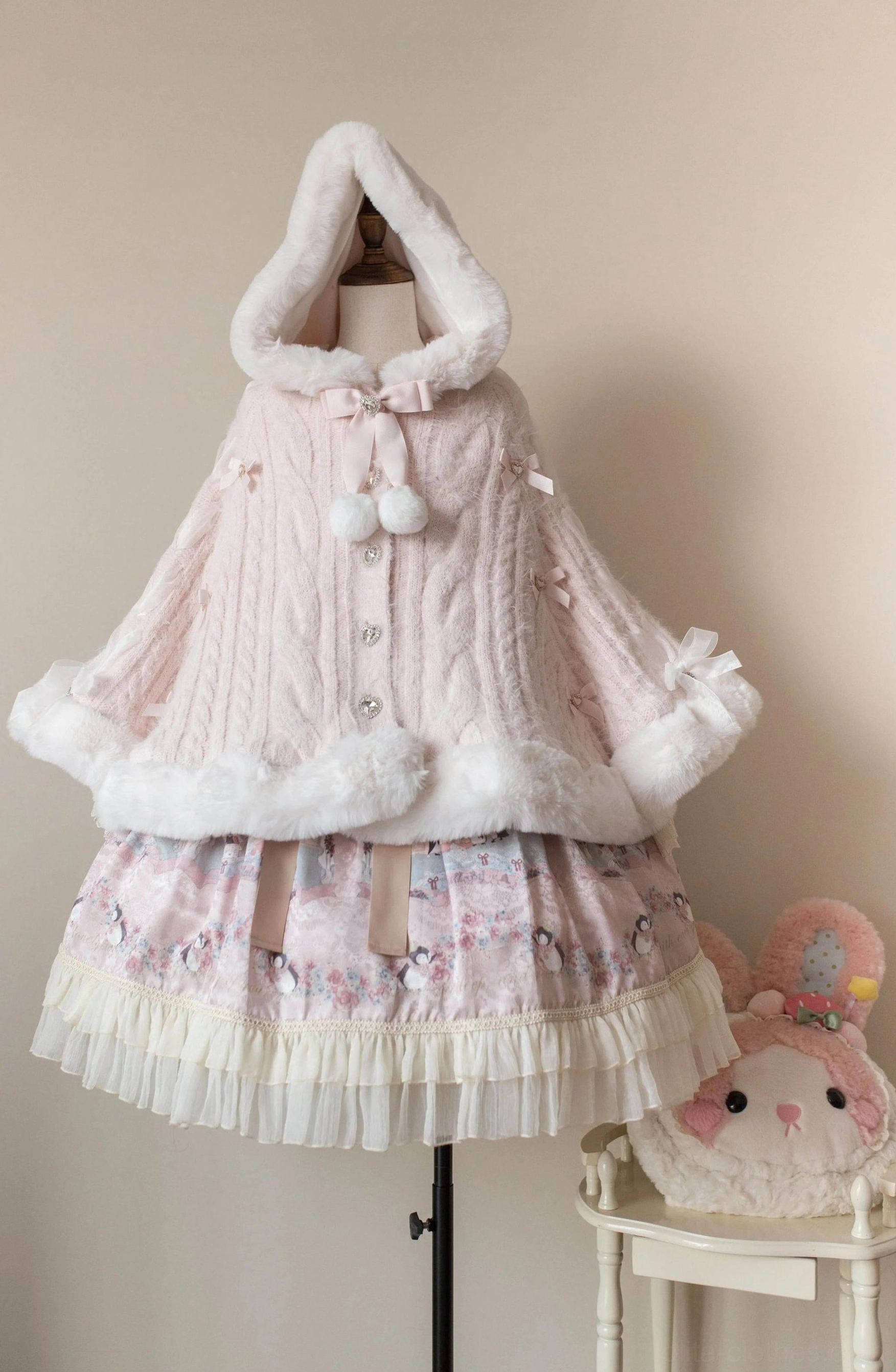 White lolita winter cape coat styled with complete sweet lolita coordinate including ruffled skirt, lace accessories, and vintage doll-inspired aesthetic ensemble