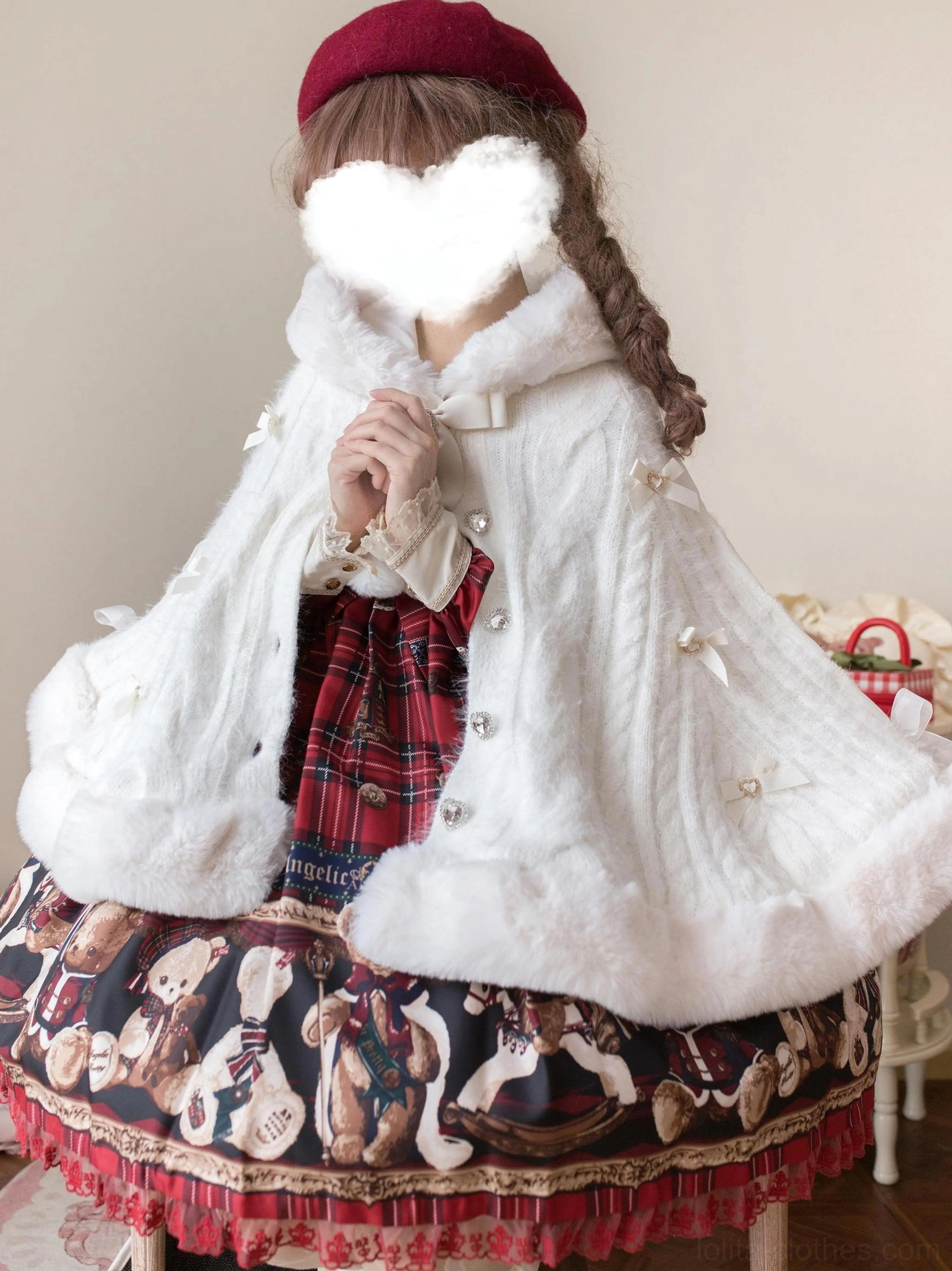 White faux fur lolita winter cape coat front three-quarter close-up showing button front closure, bow collar detail, pearl-like embellishments, styled with red plaid dress