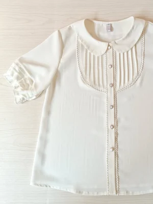 white lolita chiffon blouse top down flat lay view showing peter pan collar front button placket chest pintuck panel ruffled elbow sleeves