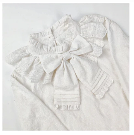 Detailed close-up of white lolita cotton blouse collar showing crocheted lace ruffled neckline large fabric bow with pleated ribbon trim delicate woven cotton
