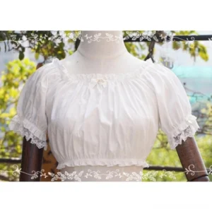 white off-shoulder Lolita summer blouse with puff sleeves and lace ruffles displayed on dress form in garden setting