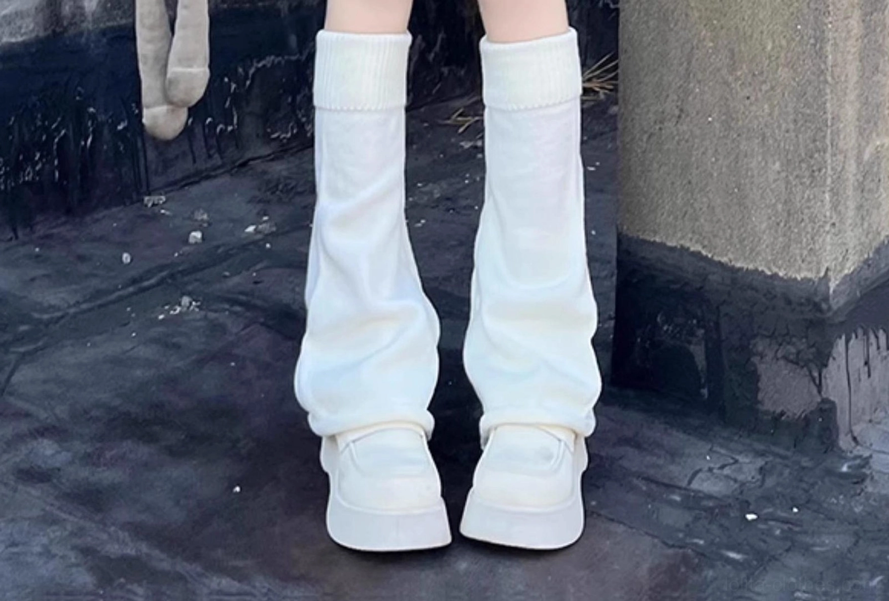 Pure white ribbed knit lolita leg warmers flat lay close-up concrete wall background with platform sneakers full length