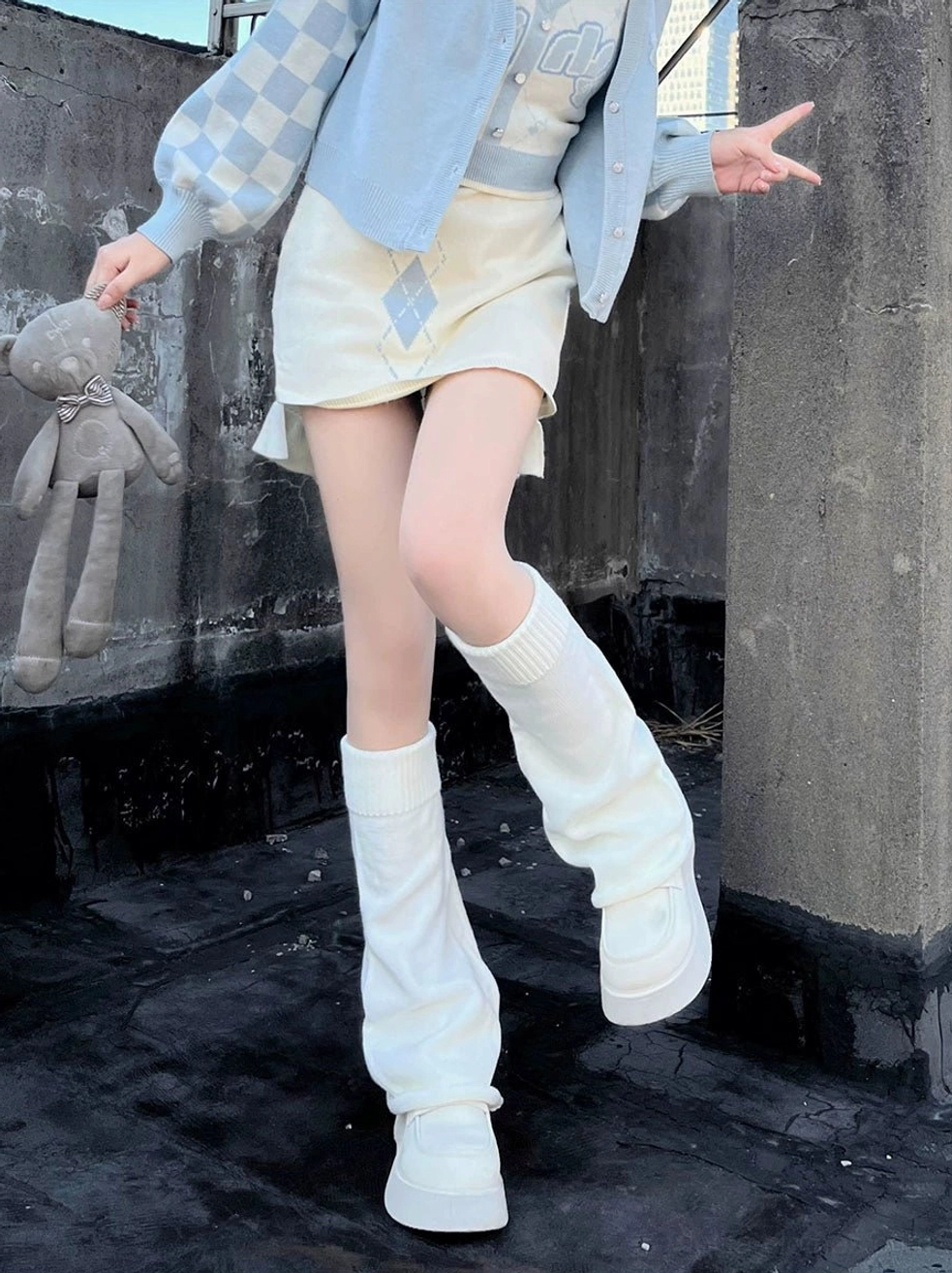 White mid-calf knitted leg warmers lolita style front full view model legs outdoor rooftop checkered cardigan mini skirt