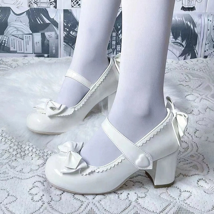 White Lolita Mary Jane block high heel shoes with scalloped edge front bow heart-shaped buckle chunky block heel and rear bow overhead close-up on embroidered lace cloth