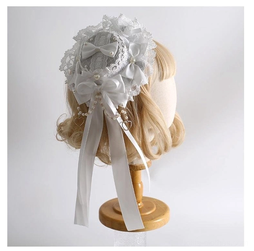 Pure white lolita mini top hat with lace base, multiple satin bows, pearl tassel hanging details back three-quarter view