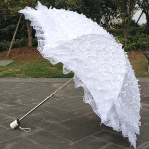 White foldable lolita sunscreen parasol with delicate bow accents and layered lace trim, fully opened displaying oblique angle view with stainless steel pole and white wrist strap