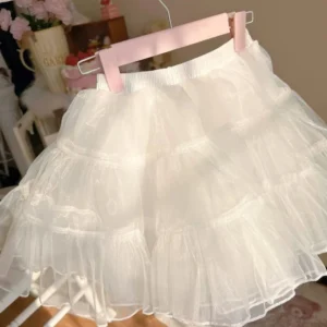 Close-up hanging front view of white layered tulle Lolita petticoat on pink wooden hanger showing multi-tiered sheer tulle layers and elastic waistband with full flared skirt shape