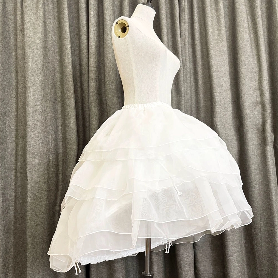 Right side profile of white organza Lolita petticoat displaying full puff silhouette, layered construction, and neat ruffled hem finish