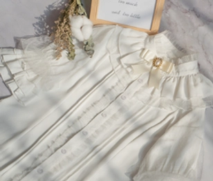 White ruffled lolita inner blouse close-up flat lay with dry flowers and decorative props stand collar lace detail